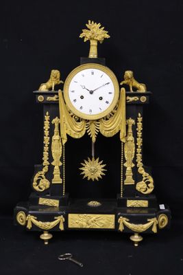 a black and gold clock sitting on a black table