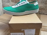 a pair of green and white shoes on top of a cardboard box