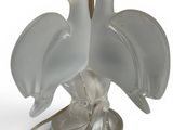two birds that are sitting on a table lamp