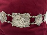 un gros plan d'une ceinture ornée de boucles en argent