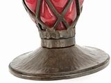 a vase with a red glass inside of it on a stand
