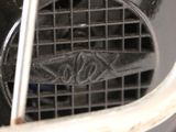 a close up of a metal grill grate with a sign on it