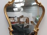 un miroir posé sur le sol à côté d'une chaise