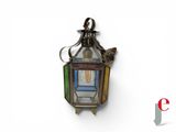 a small lantern hanging on the wall with a bird on it