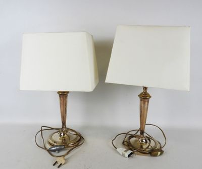 une paire de lampes de table en laiton avec des abat-jours blancs et des cordons