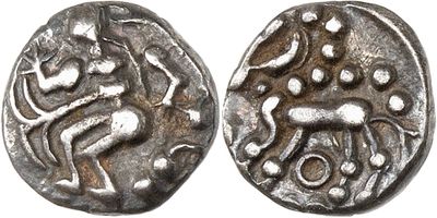 a silver coin with an image of a man and a dog on it