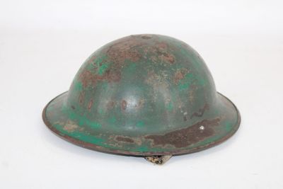 an old helmet is sitting on a white surface with a white background