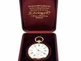 une boîte avec une montre à l'intérieur sur une surface blanche