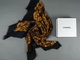 a black and gold scarf and a box of chanel perfume