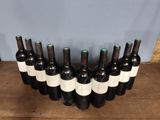 six bottles of wine lined up in a row on a wooden table