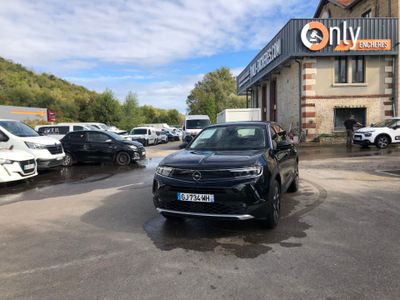 des voitures garées devant un immeuble, sur un parking