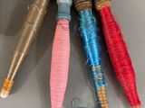several different colored thread spools are on a gray surface