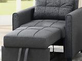un fauteuil gris et un pouf dans un salon avec un tapis