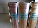trois livres posés sur un support en bois