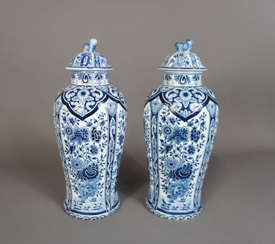 une paire de vases bleus et blancs avec couvercles, sur fond gris