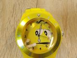 a yellow watch with a face on it on a wooden table