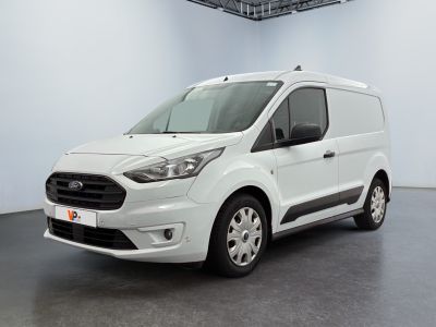 La camionnette blanche est garée dans une grande pièce blanche.