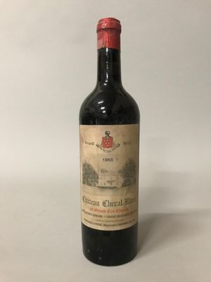 une vieille bouteille de vin posée sur une table blanche