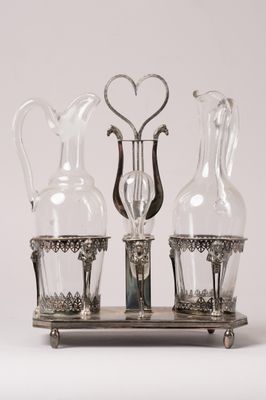 trois vases en verre posés sur un socle, avec un cœur au milieu