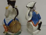 two figurines of a man and a woman sitting on a barrel
