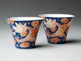 pair of blue and orange cups with dragon designs on them