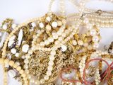 a pile of gold and pearl necklaces and bracelets