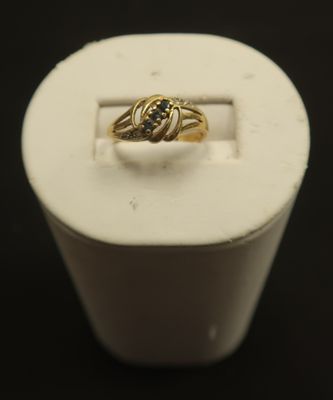 a close up of a gold ring with a black diamond in it