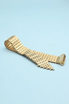 gold - plated watch band for a rolex watch on a blue background