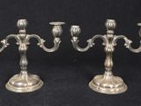 a pair of silver plated candlesticks on a black background
