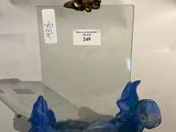 une sculpture en verre représentant un poisson, exposée sur une table