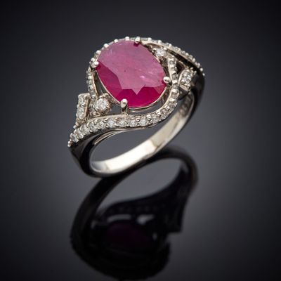 une bague en tourmaline rose et diamants posée sur un fond noir