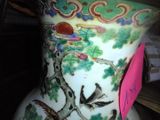 a vase with a bird on it sitting on a shelf