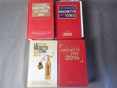 trois livres posés sur une table, avec une bouteille de vin devant eux