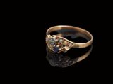 un gros plan d'une bague en or sertie de deux diamants sur un fond noir