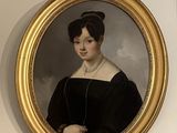 un tableau représentant une femme en robe noire, dans un cadre doré