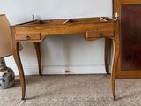 a wooden desk with a mirror and a lamp on it