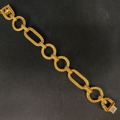 gros plan d'un bracelet en chaîne en or sur fond noir