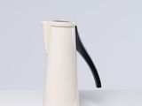 une cafetière blanche et noire posée sur une table blanche