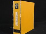 an old yellow book sitting on top of a black table