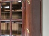 a large wooden cabinet with glass doors in a room