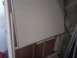 un tableau blanc posé sur un support dans une pièce