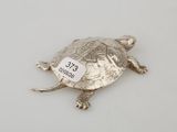 an image of a silver turtle with a tag on it ' s back