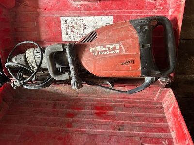 un outil rouge dans une boîte rouge, muni d'un cordon