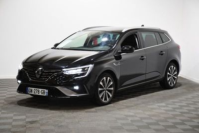 Une voiture noire est garée sur un sol à damier dans une pièce.