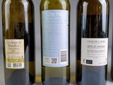 three bottles of wine are lined up on a table