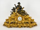 une horloge en or surmontée d'une statue
