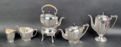 a silver tea set on a table next to other silver items