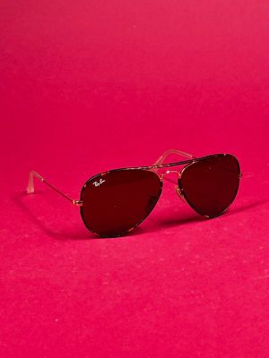 a pair of sunglasses sitting on top of a pink surface
