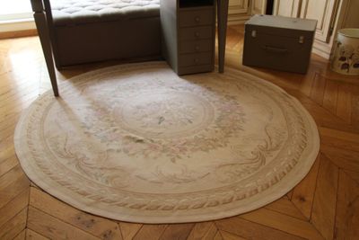 un grand tapis rond posé au sol dans une chambre à coucher