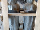 three statues of people on a shelf in a room
